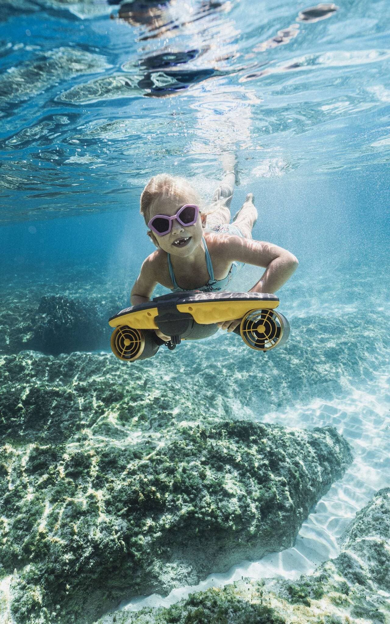 Girl on sea scooter at reef