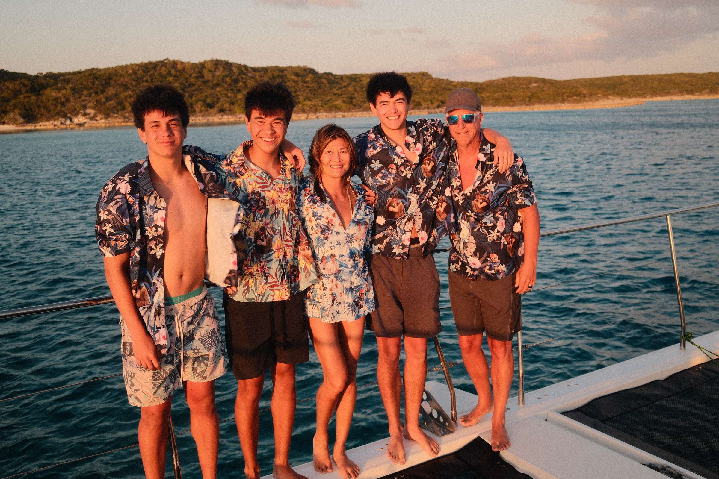 Guests in Hawaiian shirts — golden hour on the bow